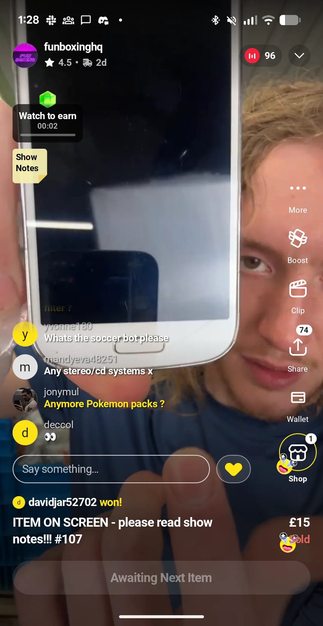 Fun Boxing HQ host on a Whatnot UK live stream holding a used Samsung smartphone close to the camera, police auction themed stream.